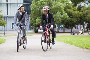 two men in business suits riding bicycles