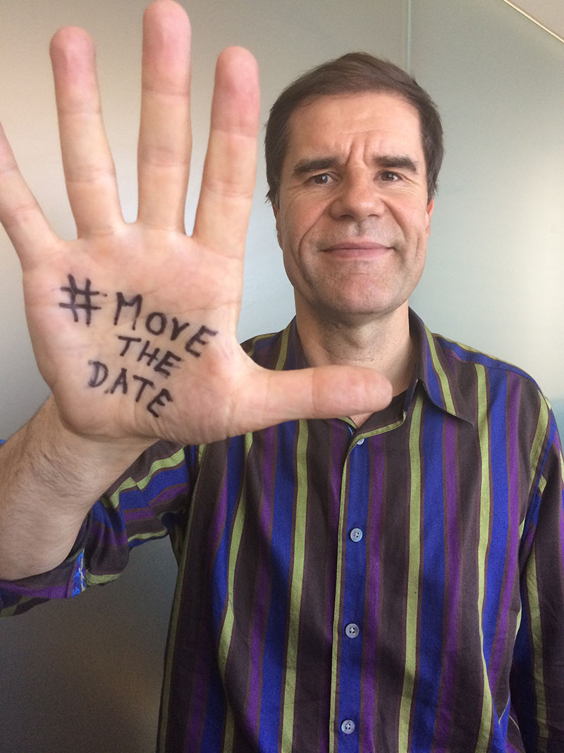Man with #MoveTheDate text on palm